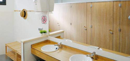 庞特维德拉Albergue Nacama Hostel Pontevedra PEREGRINOS PILGRIMS的一间带两个盥洗盆和大镜子的浴室
