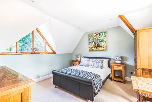 德纳姆Tilehouse lodge的卧室配有床、桌子和窗户。