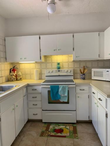 克里斯琴斯特德Sweet Serenity St Croix USVI的厨房配有白色橱柜和白色炉灶烤箱。