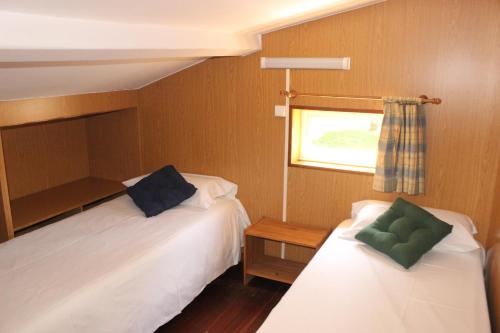 圣地亚哥－德孔波斯特拉坎西拉斯露营地的一间小卧室,配有两张床和窗户