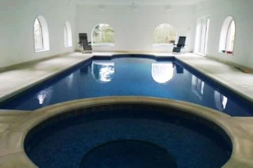 罗切斯特Country Manor House with indoor pool and hot tub的大楼内一个蓝色的大型游泳池