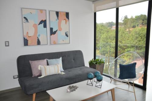 危地马拉Cozy Stays Cayala Apartments 5的客厅配有沙发和桌子