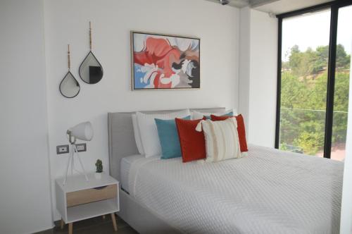 危地马拉Cozy Stays Cayala Apartments 5的白色的卧室设有床和窗户