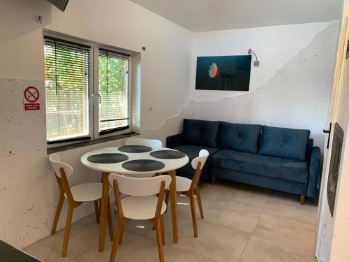 库瑞尼卡慕斯卡Domek Pensjonat Syrena的客厅配有蓝色的沙发、桌子和椅子