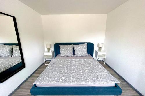 杜伊斯堡Tiny House in Duisburg by JUNIK Apartments的一间卧室配有蓝色的床和镜子