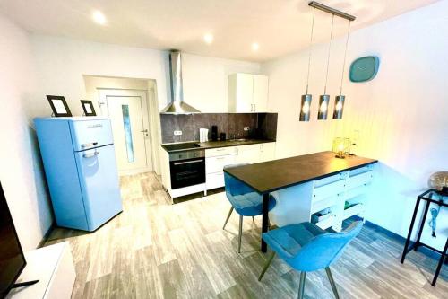 杜伊斯堡Tiny House in Duisburg by JUNIK Apartments的厨房配有桌子和蓝色冰箱。