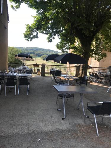 Saint-Sulpice-le-DunoisAuberge de la fontaine aux loups的一组桌椅和遮阳伞