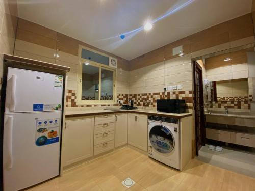 艾卜哈Quartz Executive的厨房配有冰箱和洗衣机。