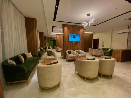 艾卜哈Quartz Executive的带沙发和平板电视的等候室