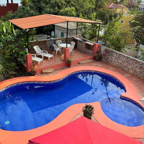 恰卡拉Casa Monarca的一个带桌子和遮阳伞的大型游泳池
