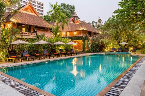 清迈Yaang Come Village Hotel - SHA Extra Plus的度假村前的游泳池