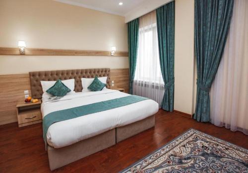 奇姆肯特Park Hotel al Bustan的一间卧室设有一张大床和一个大窗户