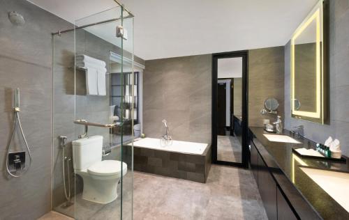 泗水Grand Swiss-Belhotel Darmo的浴室配有卫生间、盥洗盆和淋浴。