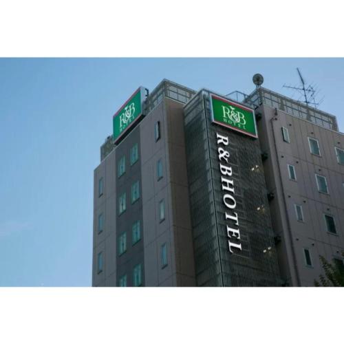名古屋R&B Hotel Nagoya Nishiki - Vacation STAY 37481v的上面有两个绿色标志的建筑
