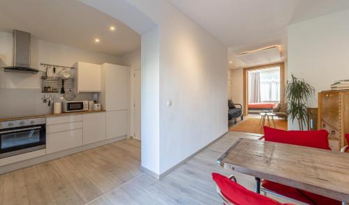 列日Lyves的厨房以及带木桌和红色椅子的客厅。