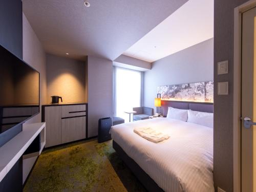 京都Hotel Forza Kyoto Shijo Kawaramachi的卧室设有一张白色大床和一扇窗户。