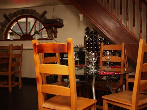 霍姆弗斯Rooms at The Nook的用餐室配有桌椅和葡萄酒瓶