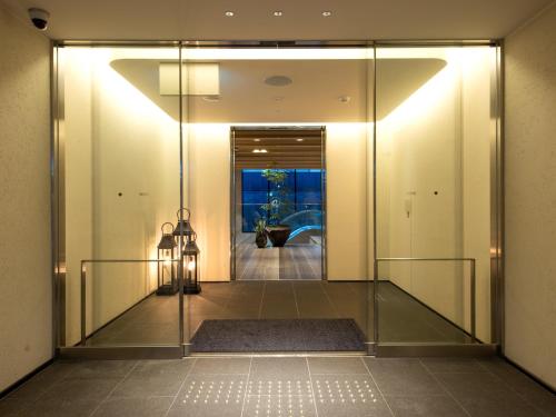 京都Hotel Forza Kyoto Shijo Kawaramachi的走廊上设有玻璃门,通往房间