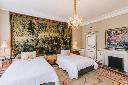 BoussacChâteau La Creuzette的墙上画画的房间里设有两张床