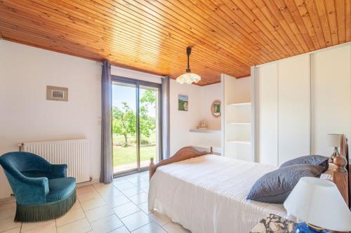 Saint-Méard-de-GurçonGîte Laulerie的一间卧室配有一张床和一张蓝色椅子
