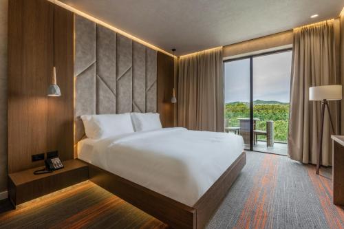 格勒姆Pinea Hotel Resort & Spa的一间卧室设有一张大床和一个大窗户