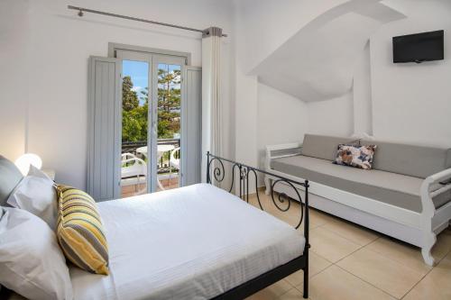 费拉苏拉别墅酒店的一间卧室配有一张床和一张沙发,并设有一个阳台