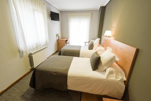 奥巴尔克伊洛Hotel Porto do Barqueiro的酒店客房设有两张床和窗户。