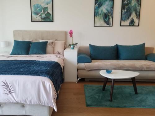 贝尔格莱德Azura Residence - new luxury apartment的一间卧室配有一张床、一张沙发和一张桌子