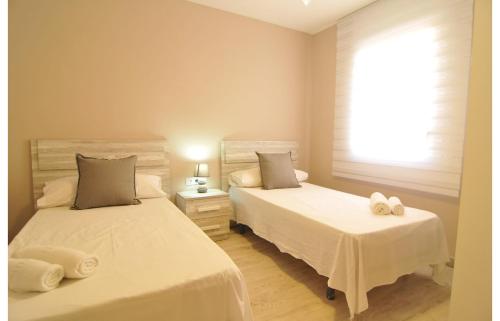 卡内·德·玛尔HomeHolidaysRentals Canet Playa I的一间卧室配有两张带毛巾的床