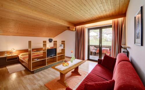 帕尔奇内斯淘恩布鲁恩公寓式酒店的客厅配有红色的沙发和床。