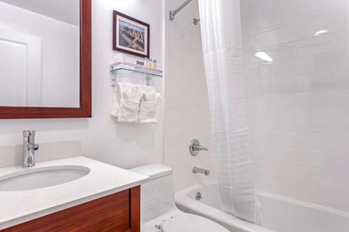 皇后区Avion Inn Near LGA Airport, Ascend Hotel Collection的白色的浴室设有水槽和淋浴。