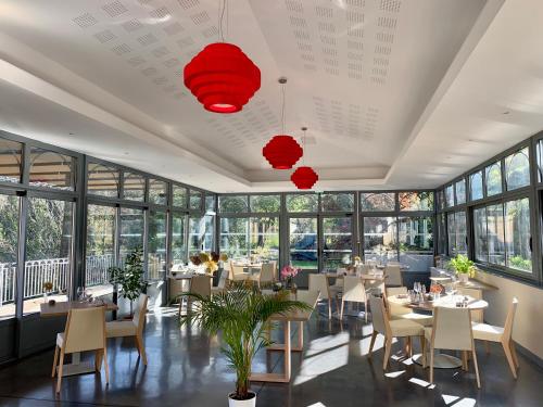 Saint-Gervais-sur-MareL'Ortensia的餐厅设有桌椅和窗户。