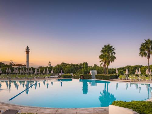 厄尔-汝姆披多富而特埃尔隆皮多水疗酒店的一个带遮阳伞和钟楼的大型游泳池