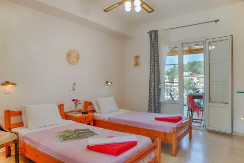 卡西奥皮MANESSIS Apartments Kassiopi Bay Corfu的一间带两张床的卧室和一个阳台