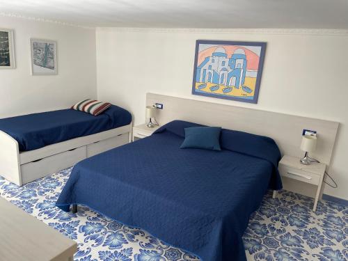 伊斯基亚Casetta del pescatore的一间卧室配有两张蓝色床单
