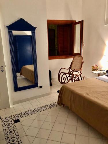 马里迪莫Sulle ali del Mediterraneo的一间卧室配有一张床、镜子和椅子