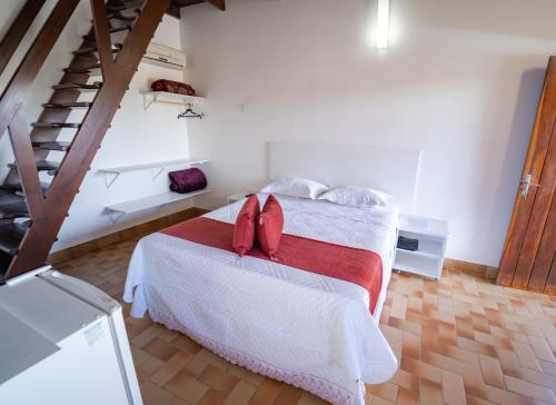 戈亚斯州上帕莱索Pousada Cachoeira Poço Encantado的一间卧室配有一张带红色枕头的床