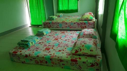 Ban Tha Ling LomBaan Rai Pray Rung Kaeng Krachan的配有床罩和枕头的双床间