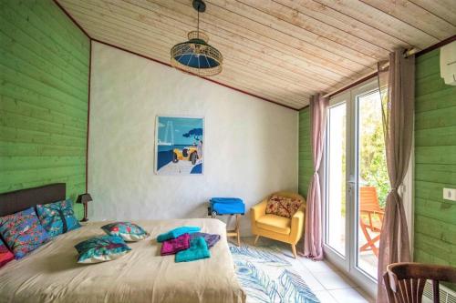 YvesMerlettes des Sables的一间卧室设有绿色的墙壁、一张床和窗户
