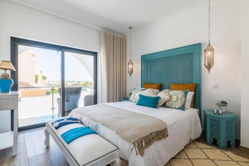 吉亚Riad Matias Galé - Luxury Villa with private pool, AC, free wifi, 5 min from the beach的一间带大床的卧室和一个阳台