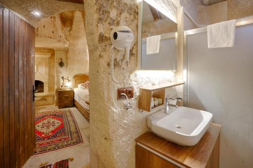 格雷梅郁金香洞穴套房酒店的一间带水槽的浴室和一张位于客房内的床