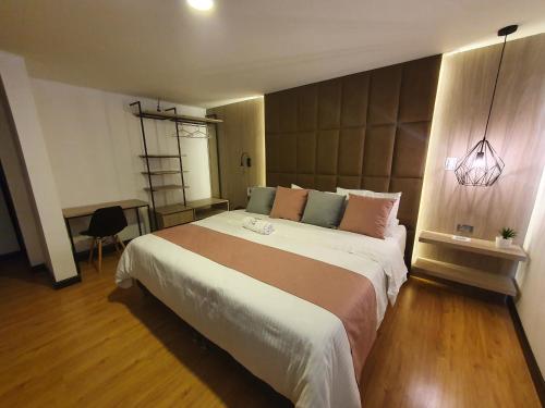 帕斯托HOTEL SANTORI的一间卧室配有一张大床和一盏灯