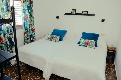 奇瓦Los Olivos的一间卧室配有白色床和蓝色枕头