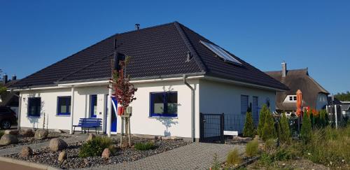格洛韦Haus Kliffblick的一间黑色屋顶的白色小房子