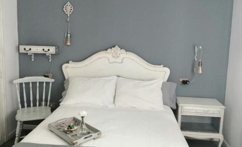 拉科鲁尼亚Apartamento Acogedor en la Coruña的卧室配有白色的床和椅子