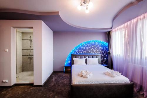 MiladinowziХотел ПИРГУЛЯ的一间卧室配有一张蓝色墙壁的床