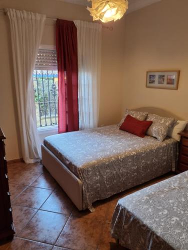 圣玛丽亚港VACACIONES DE LUJO.CHALET PISCINA Y PLAYA.EL PUERTO的一间卧室设有两张床和窗户。