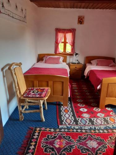 耶蒂斯特Etno guest house Lalovic的卧室配有两张床、椅子和地毯。