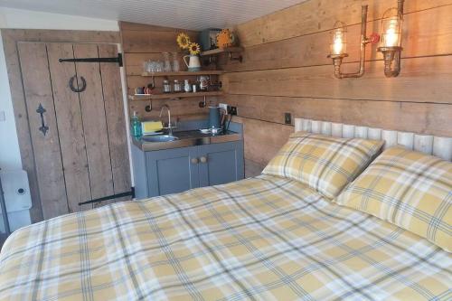 特罗布里奇Crown Cabin Wiltshire near Longleat and Bath的一张床上,床上有铺着铺盖的毯子