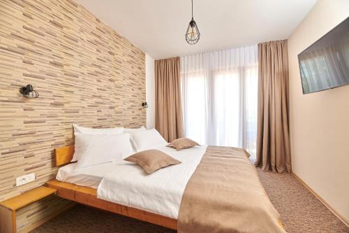 乌马格Sobe Sole的一间卧室设有一张大床和砖墙